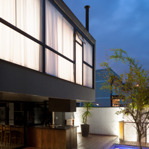 Vista noturna da Fachada Posterior  e área de lazer da casa. (Ar:Co – Arquitetura Cooperativa).