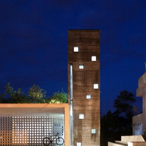 Vista noturna da caixa de concreto que protege a circulação vertical. (Ar:Co – Arquitetura Cooperativa).