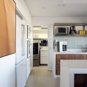 Vista do Corredor para a Cozinha e Área de Serviço. (Ar:Co – Arquitetura Cooperativa).