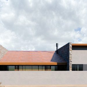 Fachada Posterior com muro de divisa. (Ar:Co – Arquitetura Cooperativa).